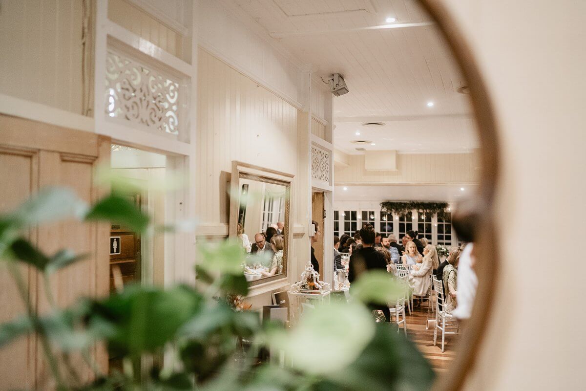 Reflection in a mirror of guests gathered for a private event in the Rosewood Room at Hillstone St Lucia
