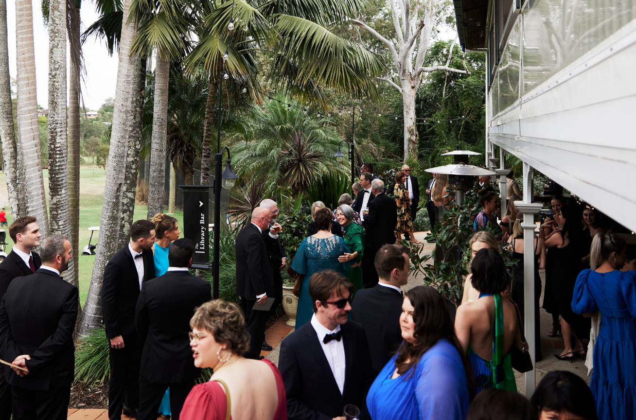 Wedding reception guests gathered outdoors with nature backdrop at Hillstone St Lucia, Brisbane.