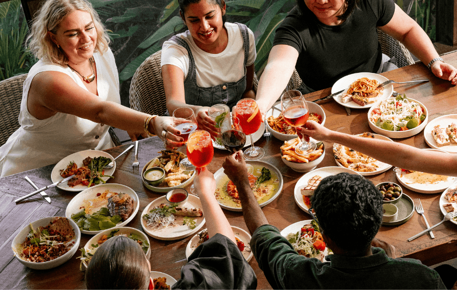 People gathered around a dining table at St Lucia restaurant in Brisbane