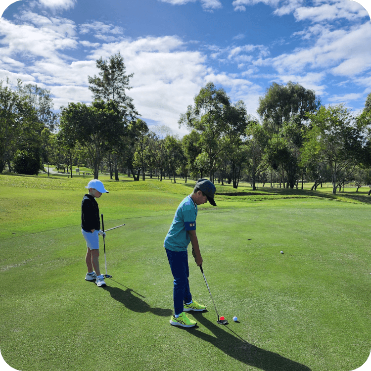 Two kids hitting golf balls at golf course in Brisbane