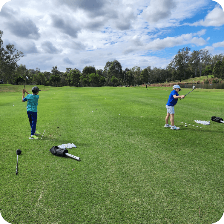 Two kids hitting golf balls at golf lessons in Brisbane