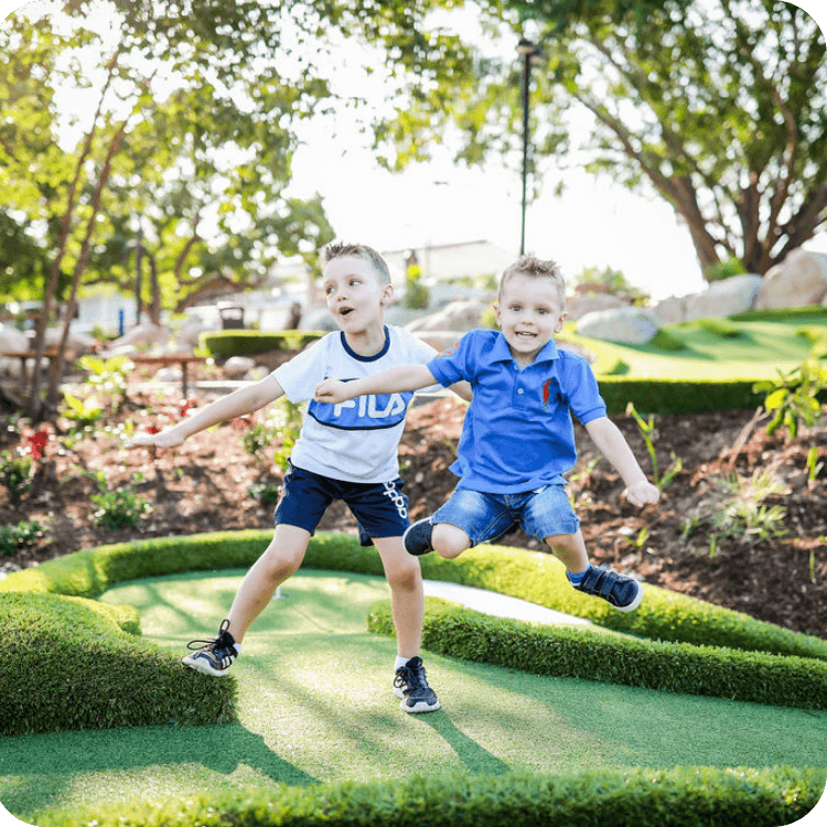 Two kids jumping at a mini golf course in Brisbane