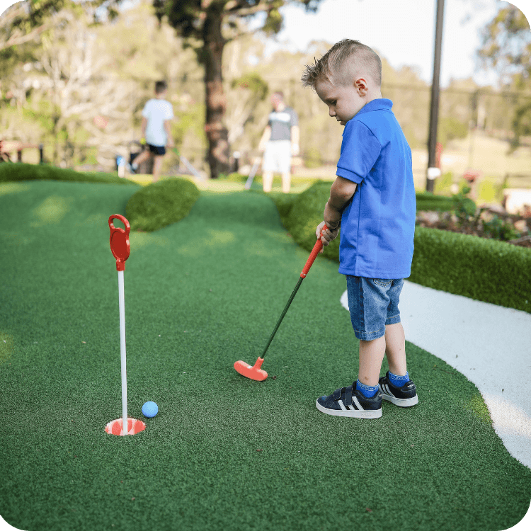 A child playing putt putt mini golf in Brisbane